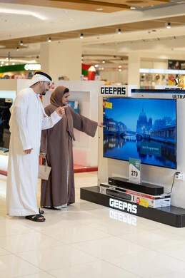 زوجان إماراتيان يتسوقان لشراء تلفزيون في متجر إلكترونيات