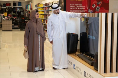 زوجان إماراتيان يتسوقان لشراء تلفزيون في متجر إلكترونيات