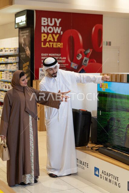 Emirati Couple Shopping for Television in Electronics Store