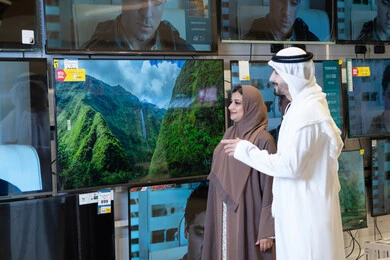 Emirati Couple Shopping for Television in Electronics Store