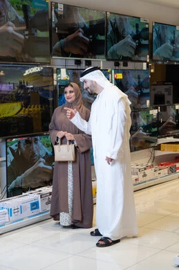 زوجان إماراتيان يتسوقان لشراء تلفزيون في متجر إلكترونيات