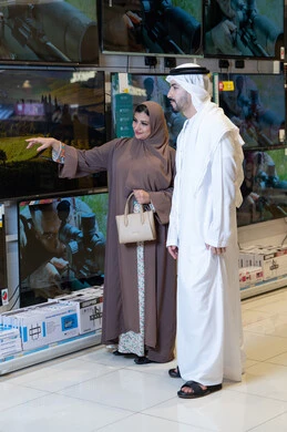 زوجان إماراتيان يتسوقان لشراء تلفزيون في متجر إلكترونيات