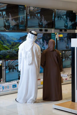 زوجين إماراتيين يتسوقان لشراء شاشات تلفاز في متجر