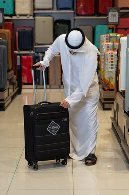 Emirati Man Inspecting Suitcase in Luggage Store