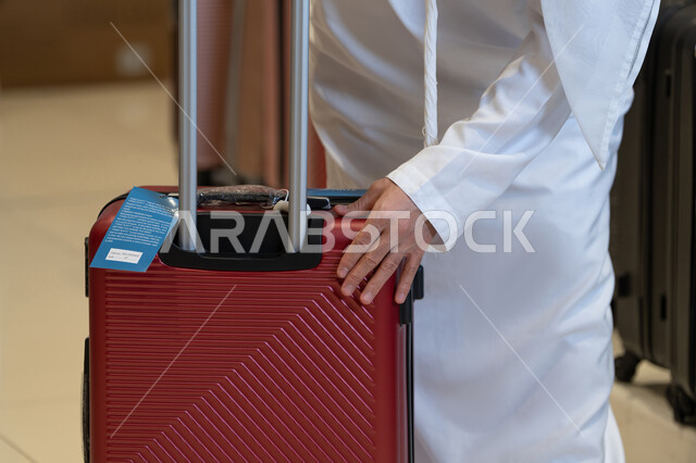 Emirati Man in White Kandura with Red Suitcase Travel