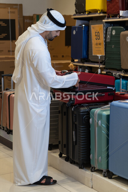 Emirati Man Inspecting Suitcase in Luggage Store
