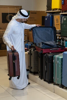 رجل إماراتي يتسوق لشراء حقائب السفر في المتجر رجل إماراتي يتسوق لشراء حقائب السفر في المتجر