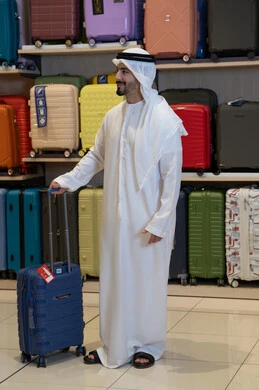 رجل إماراتي يتسوق لشراء حقائب السفر في المتجر