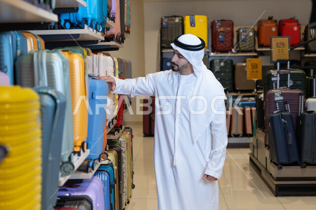 رجل إماراتي يتسوق لشراء حقائب السفر في المتجر