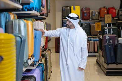 Emirati Man Shopping for Suitcases in Luggage Store