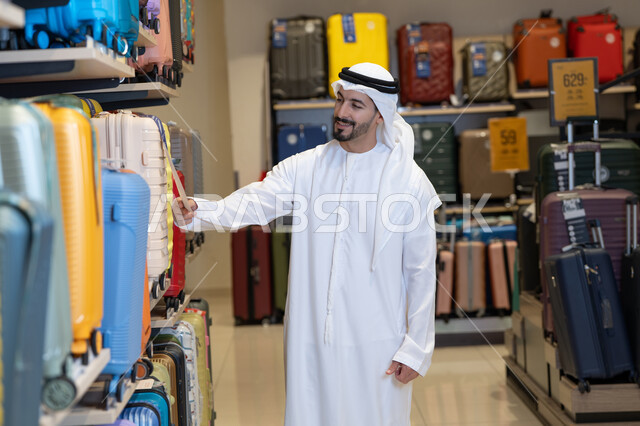 رجل إماراتي يتسوق لشراء حقائب السفر في المتجر