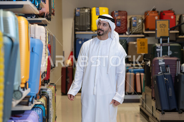 رجل إماراتي يتسوق لشراء حقائب سفر في متجر