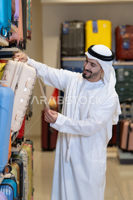 رجل إماراتي يتسوق لشراء حقيبة سفر في متجر