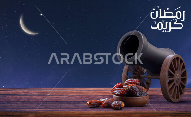 صورة لمدفع الإفطار في شهر رمضان ، رمضان كريم ، مدفع الإفطار ، مدفع عتيق ، مدفع رمضان مع خلفية سماء في وضع الليل وهلال ، مجموعة من حبات التمر ، فطور رمضاني ، هلال شهر رمضان ، شهر الخير