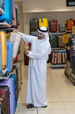 Emirati Man Shopping for Luggage in Retail Store
