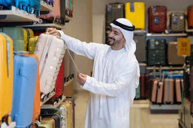Arab Man Shopping for Luggage in Retail Store