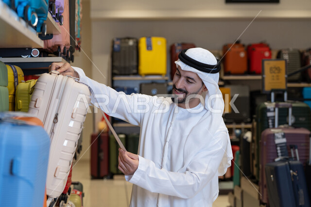 رجل إماراتي يتسوق لشراء حقيبة سفر في المتجر