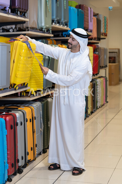 رجل إماراتي يتسوق لشراء حقائب السفر في المتجر