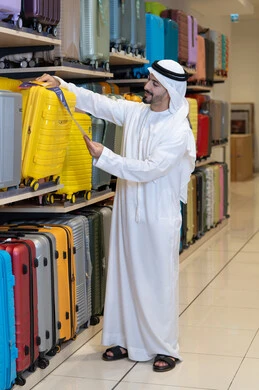Emirati Man Shopping for Travel Luggage in Retail Store Emirati Man Shopping for Travel Luggage in Retail Store