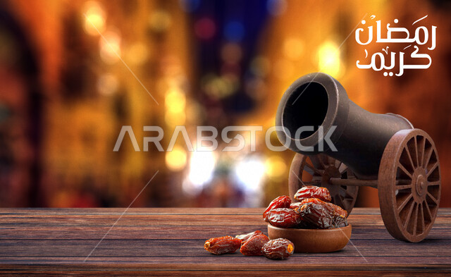 صورة لمدفع الإفطار في شهر رمضان ، رمضان كريم ، مدفع الإفطار ، مدفع عتيق ، مدفع رمضان مع خلفية زخرفية مجردة لإنعكاس ضوئي وقت الليل غير واضحة ، مجموعة من حبات التمر ، فطور رمضاني ، شهر الخير