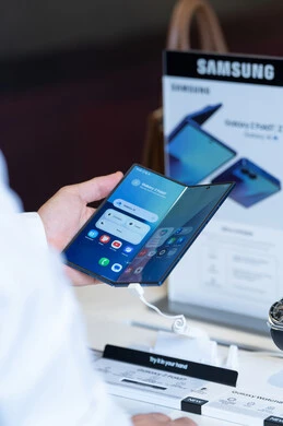 رجل عربي يستخدم هاتف سامسونج جالكسي القابل للطي في متجر