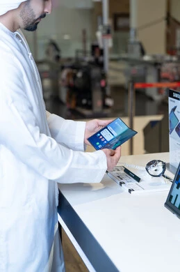 رجل إماراتي يتفحص هاتف ذكي في متجر إلكترونيات