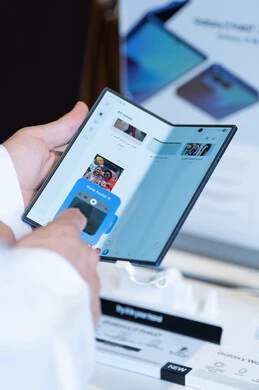 Saudi Man in Thobe Using Foldable Smartphone