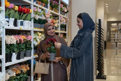 نساء سعوديات يتسوقن زهور صناعية في متجر ديكور