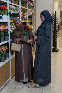 سيدات سعوديات بالعباءة يتسوقن الزهور في متجر