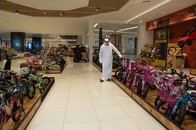 رجل إماراتي يتسوق لشراء الدراجات في متجر تجزئة