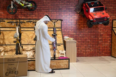 رجل إماراتي يتسوق في متجر دراجات وألعاب
