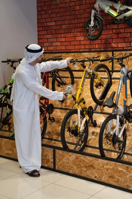 رجل إماراتي يتفحص الدراجات الهوائية في معرض تجاري