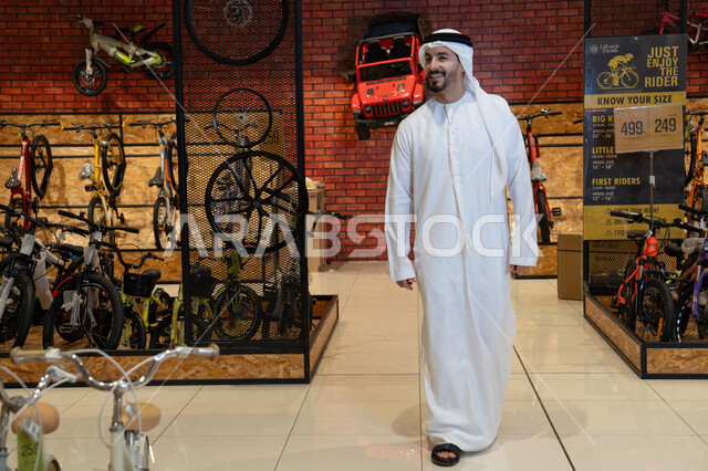 رجل إماراتي بالكندورة التقليدية في معرض دراجات هوائية