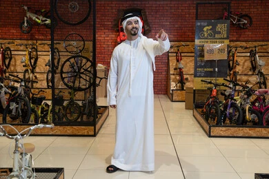 رجل إماراتي يتسوق في متجر دراجات هوائية