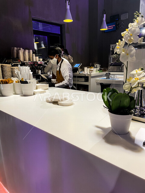 صورة من داخل مطبخ إحدى المطاعم أو الفنادق في السعودية ، مرأة تعمل كنادل تقوم بجهيز الطلبات للزبائن ، مطعم لتحضير أشهى المأكولات والمشروبات في المملكة العربية السعودية ، أماكن سياحية في السعودية