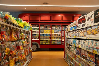 متجر ألعاب من الداخل مع رف عرض على شكل حافلة حمراء