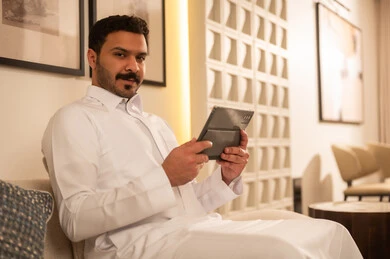 Saudi Man with Tablet in Modern Living Room