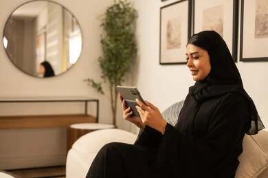 Arab Woman Using Tablet in Modern Living Room Interior