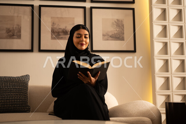 Saudi Woman in Abaya Reading Book at Home