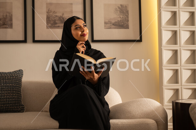 Saudi Woman Reading Book in Warm Indoor Setting