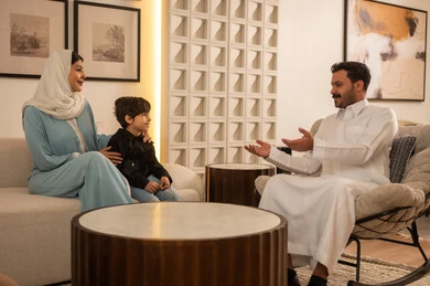 عائلة سعودية تتحدث في غرفة معيشة حديثة