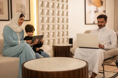Saudi Family Using Laptop and Tablet at Home