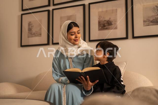 أم عربية تقرأ كتاباً مع ابنها في غرفة المعيشة