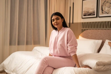 امرأة عربية بملابس رياضية وردية في غرفة النوم