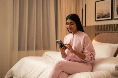 Arab Woman Using Smartphone in Modern Bedroom