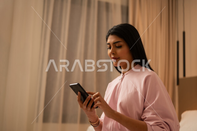 Arab Woman in Bedroom Using Smartphone