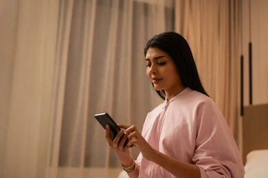 Arab Woman in Bedroom Using Smartphone