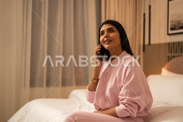 امرأة سعودية تستخدم الهاتف الذكي في غرفة النوم