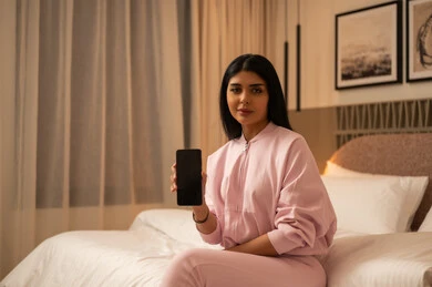 Arab Woman Holding Smartphone in Modern Bedroom