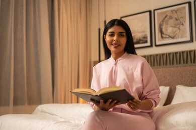 Arab Woman Reading Book in Bedroom